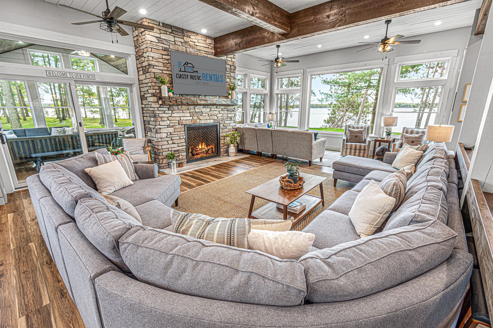 Great room with stone fireplace and lake windows